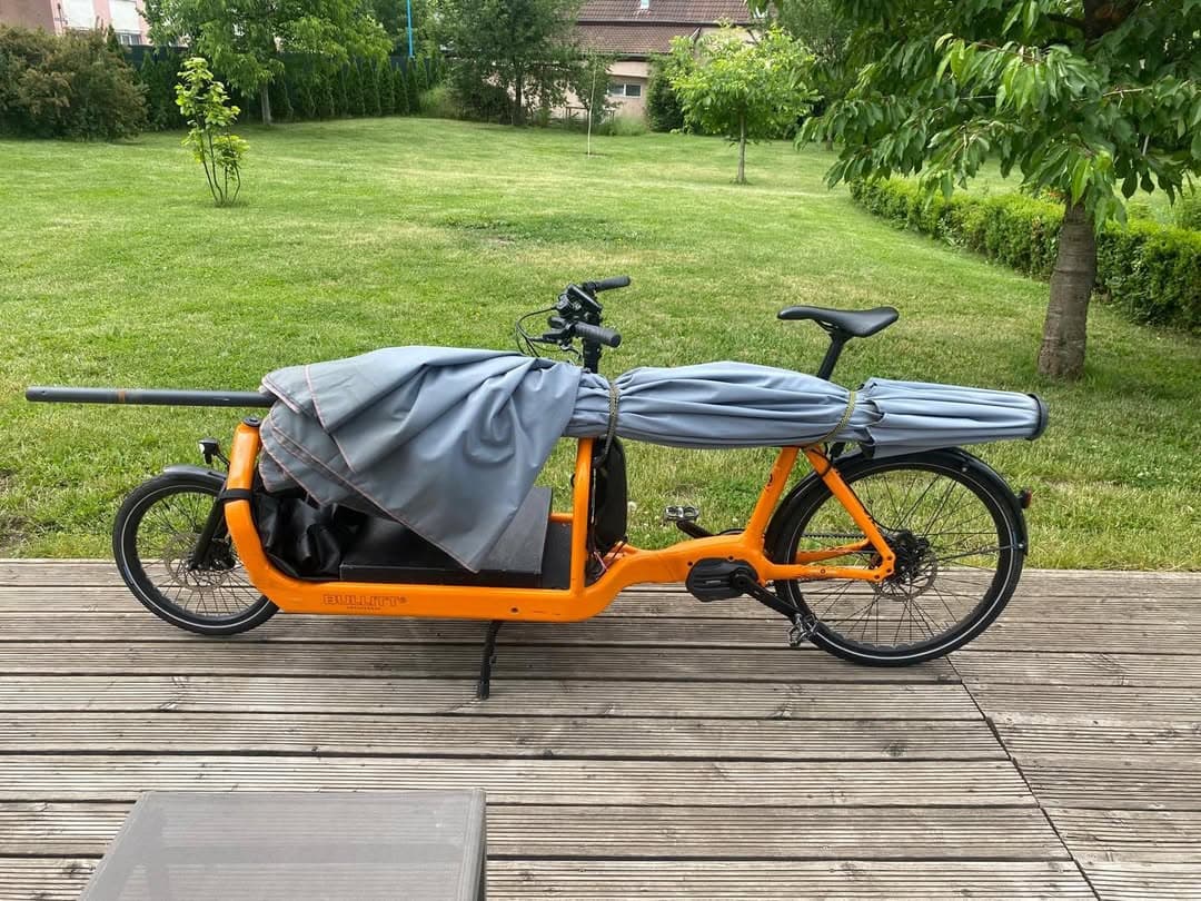 Bullitt transportând o umbrelă mare prin oraș